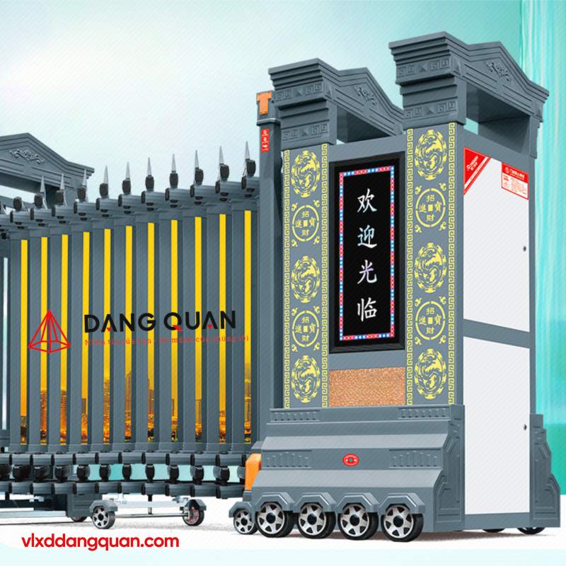 Cổng xếp nhôm tự động DQ13 có đầu kéo dạng trụ lớn mái nhiều tầng, mặt trụ hoa văn nổi, màn hình LED, thân nan đầu mũi giáo