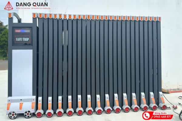 Cổng xếp nhôm màu ghi xám xếp gọn, đầu kéo có màn hình LED, chân nan gắn bánh xe và nắp cam