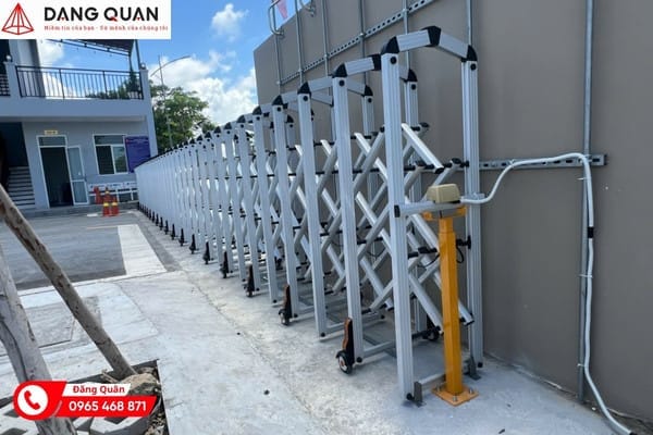 Cổng xếp tự động màu bạc xếp gọn sát tường bên lối vào, dây điện đi nổi dọc tường