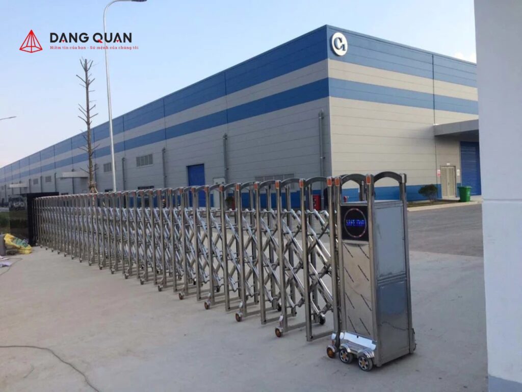Cổng xếp inox tự động không ray chạy bánh xe trên sân bê tông trước nhà xưởng
